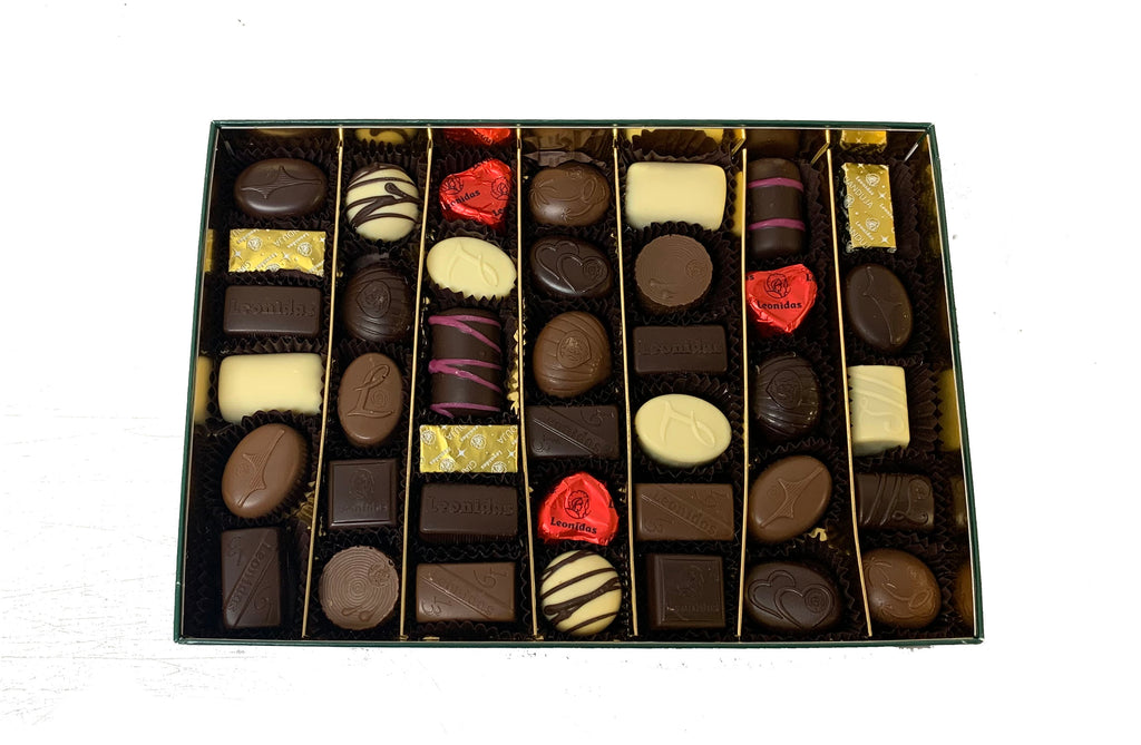 Assorted chocolates in a gold lined box on a white background