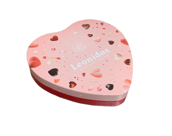 A heart-shaped tin box with a pink and red speckled design, labeled 'Leonidas' on the front.