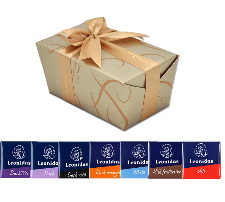 Leonidas half pound Napolitains Sampler ballotins, with a golden bow on a golden wrapped gift box, and a display of the different flavors including dark, milk, and white chocolate.